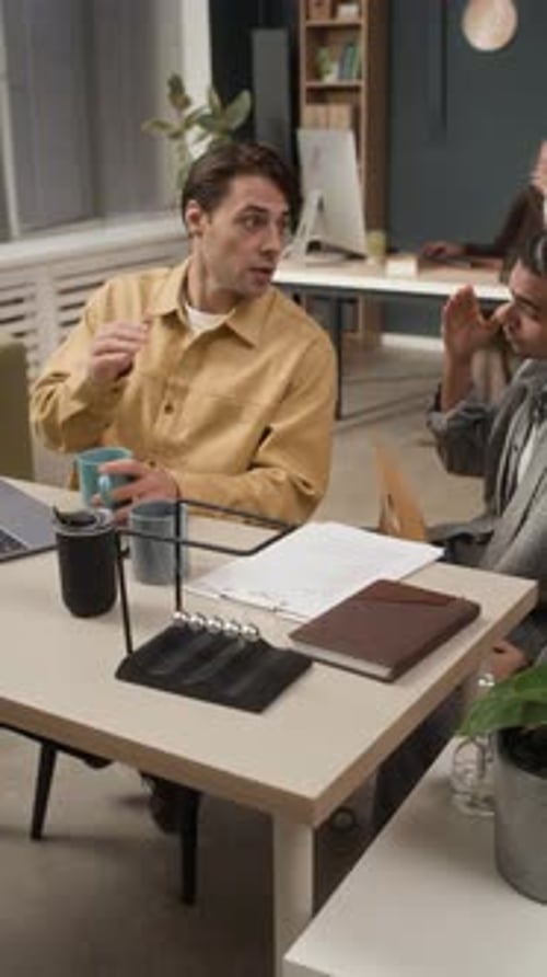 Mentor Explaining Project Details to Junior Specialist in Open Space Office