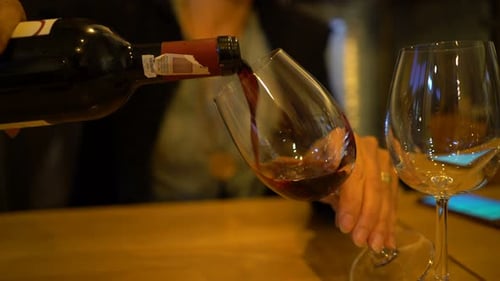Frau gießt Rotwein ins Glas im Restaurant Erwachsene
