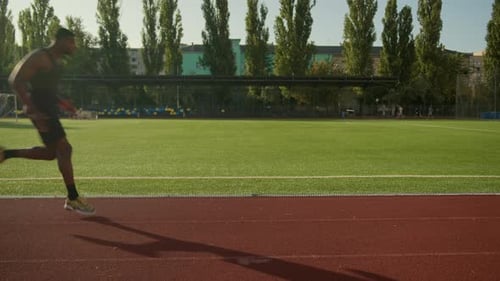 African American Man Runner Jogger Running Active Cardio Jog Exercise on City Stadium Outdoor Track