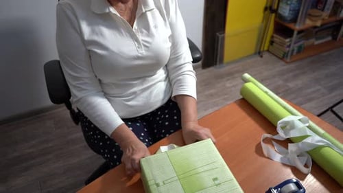 Woman Wrapping Present at Wooden Table