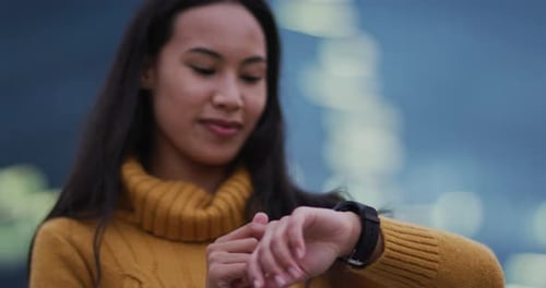 Young Woman Using Smartwatch in Urban Setting