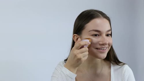 Young Woman Using Skincare Tool on Her Face
