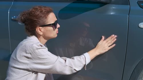 Woman Inspecting Car for Scratches and Dents