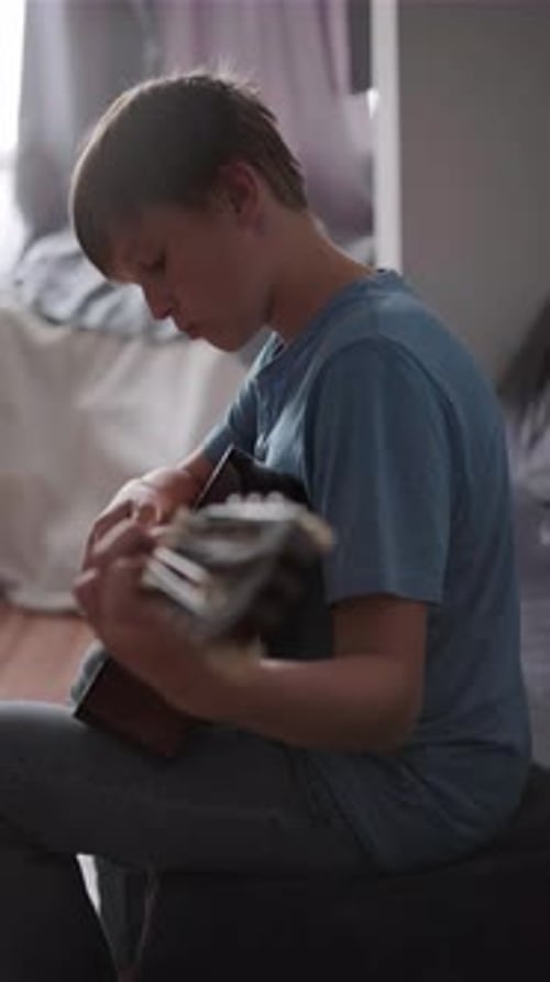 Young Boy Playing Guitar in Room
