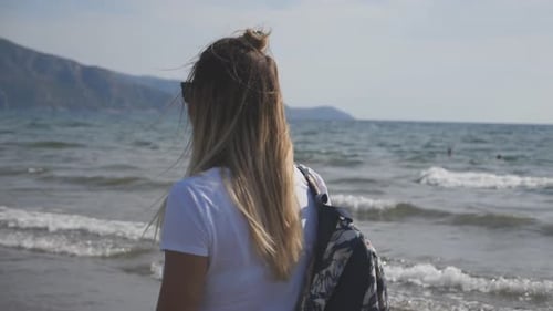 Female Traveler with Backpack Strolling Along Ocean Coast Admiring Beautiful Views Young Girl
