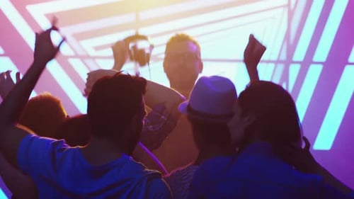 Crowd Dancing with Arms Raised in Nightclub Party