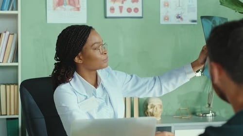 Afroamerican Woman Doctor Examines Lungs Xray of Patient Giving a Positive Feedback in Hospital or