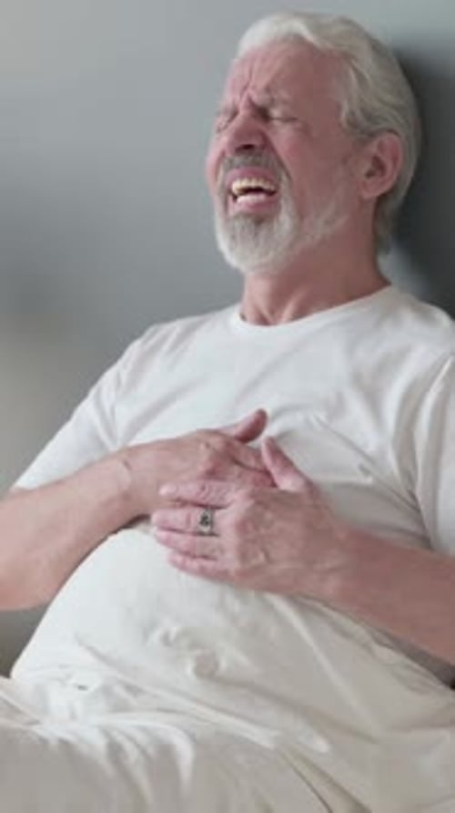 Old Man having with Chest Pain Sitting in Bed, Vertical Video