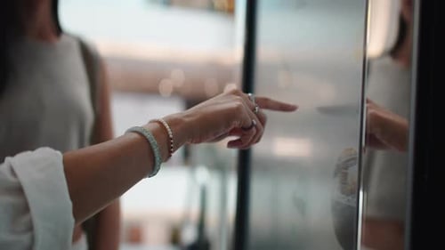 Woman's Hand Using Interactive Touchscreen Kiosk