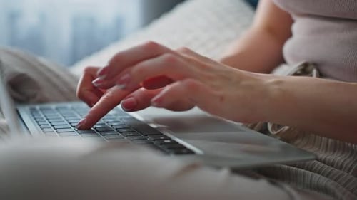 Hands Typing on Laptop in Cozy Indoor Setting During Daytime