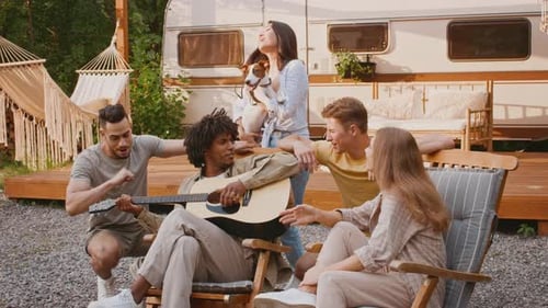 Young Adults Enjoying Music Outside Camper