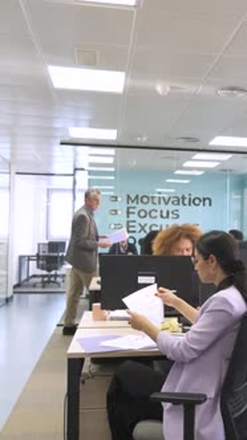 Gerente entregando arquivos para profissionais criativos no espaço de trabalho de coworking