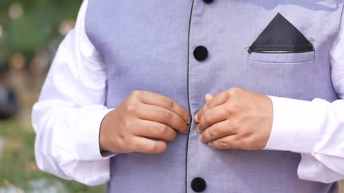 Man Buttoning His Shirt Close Up