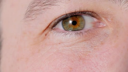 Macro Shot Of Blinking Green and Hazel Eyes Of A Caucasian Man.