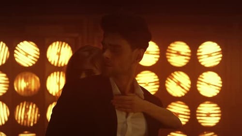 Gorgeous woman seductively dancing with handsome man in soft illumination at nightclub