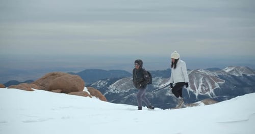 Couple Climbing Up Mountain, Hiking Rocky Mountains in Snow Adventure