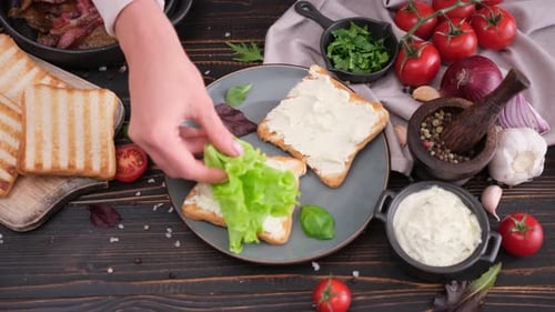 Woman Assembling Sandwich with Lettuce and Cream Cheese