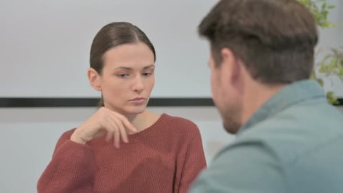 Young Woman Talking to Fellow Colleague in Office