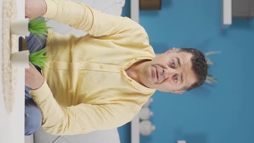 Vertical video of Old man looking at camera confused.
