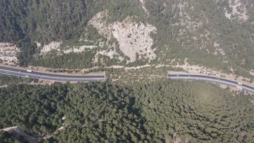 Drone view of vehicle traffic on the road and tunnel built between the mountains, intercity transpor