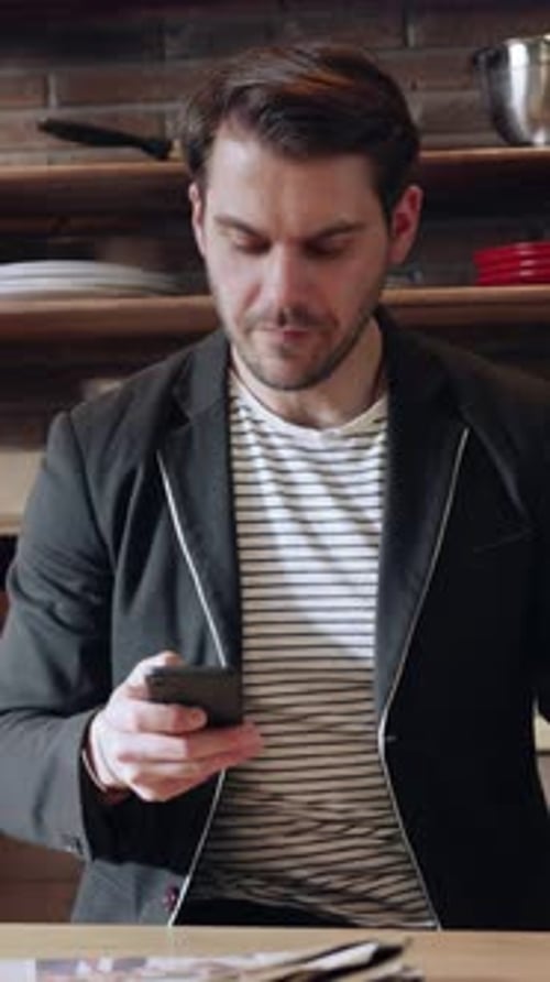 Stylish Man Using Smartphone in Modern Caf