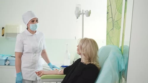 Supportive Nurse Administering IV Drip to Patient