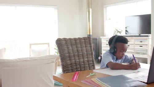 Young Boy Learning at Home, Writing on Paper