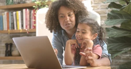 Woman and Child Enjoy Laptop at Home