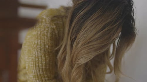 Close up of a despondent woman as she sits on the stairs