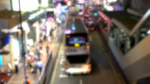 Autos und Menschen, die sich nachts in Mongkok, Hongkong, in Blur bewegen