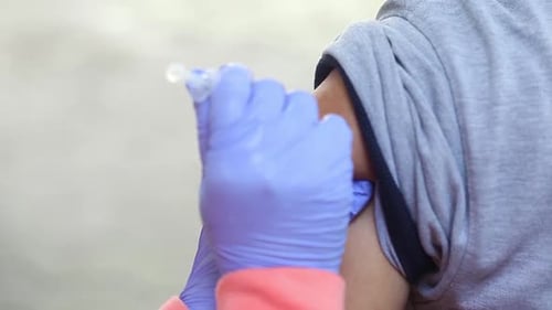 Close-up video of a man's arm being injected with the corona virus vaccine