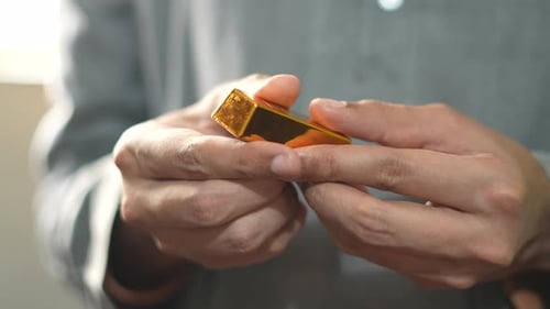 Hand Holding Shiny Gold Nugget Macro Shot