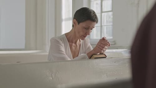Mature Woman Praying in Church