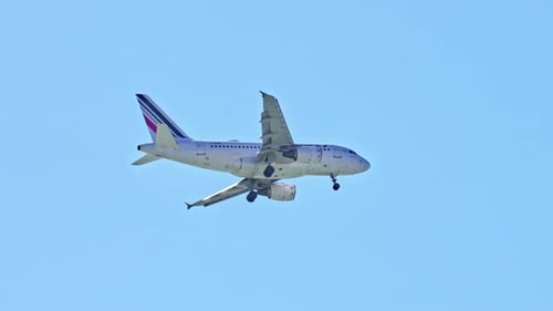 Passenger Plane Flies Through a Clear Blue Sky