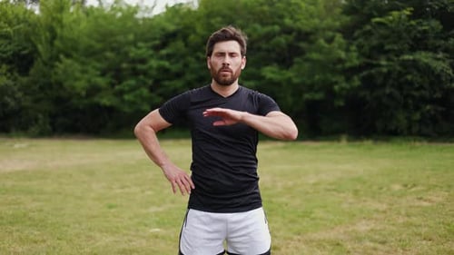 Homem concentrado estendendo os braços durante as curvas do corpo e sentindo tensão na cintura