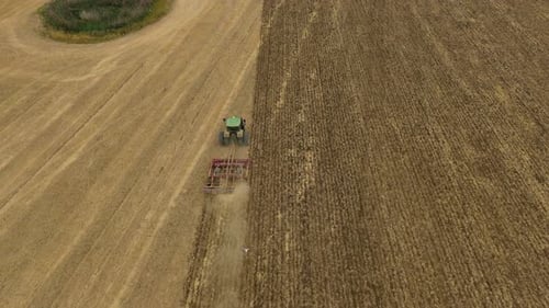 Aerial view of tractor tilling field, United Kingdom.