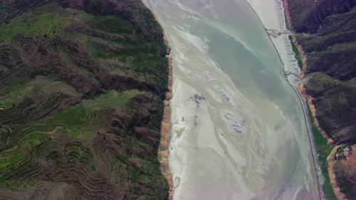 Top Aerial flight view over the river, Some houses on the mountain with Forests roads and streets