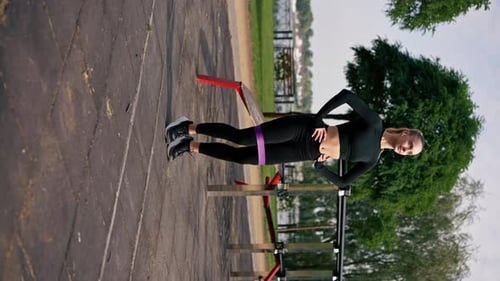 Fit Woman Exercises with Resistance Band Outdoors