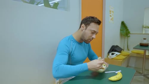 Young Adult Eating Healthy Salad at a Table
