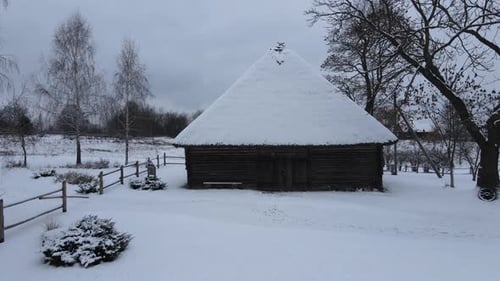 Old Barn Wooden Building in the Village Barn with a Thatched Roof in the Snow
