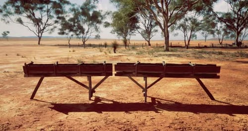 Rustic Wooden Benches Set Against a Vast Dry Landscape Under Clear Skies