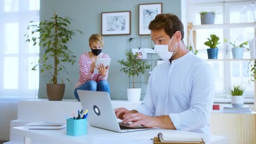 Mature Businessman and Colleague with Face Mask Indoors Working in Office