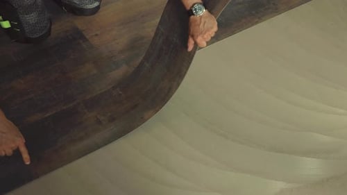 Man Installing Wood-Look Vinyl Flooring in Home