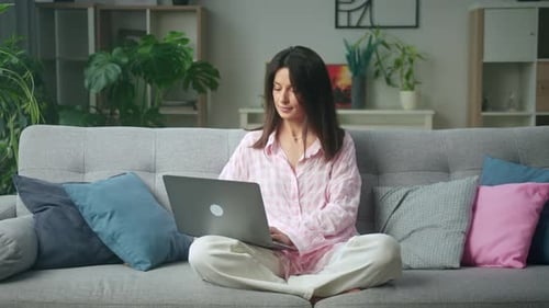 Cozy home office: woman working on laptop in stylish living room