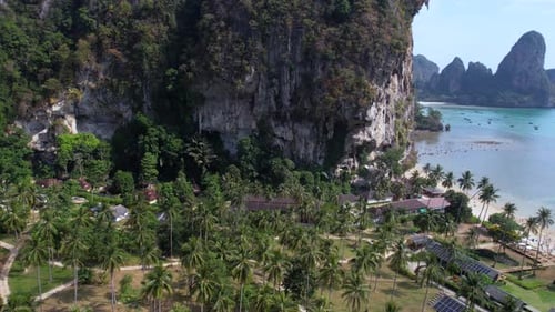 Drone Shot of Tropical Resort Beachfront Buildings With Solar Panels Under Cliffs, Railay Thailand