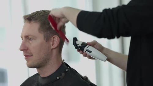 Man Getting Haircut with Clippers in Barbershop