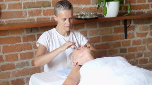 Woman Giving Face Massage to Senior Woman