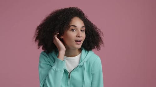 Woman Listening Intently and Smiling on Pink