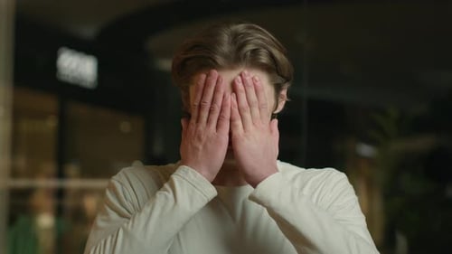 Worried Young Adult Massaging Temples Indoors