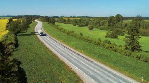 Aerial View of White Semi Truck with Cargo Trailer Moving on the Highway. In the Background with Ru